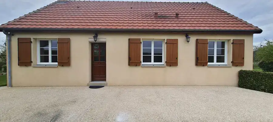 Fenêtres PVC blanches et volets battants bois sur un pavillon