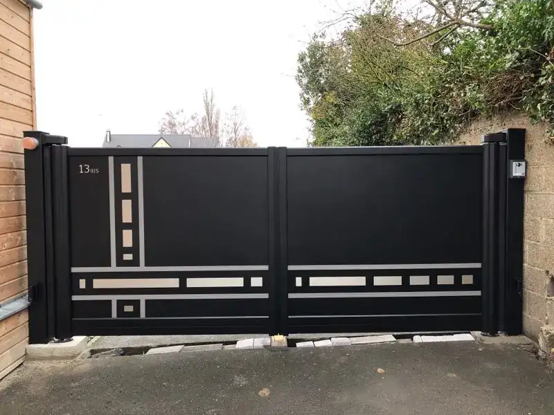 Portail aluminium noir à motifs gris entre deux piliers