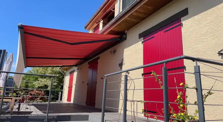Store banne rouge déployé au-dessus d'une terrasse